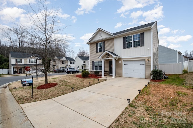 traditional home with an attached garage, driveway, and fence