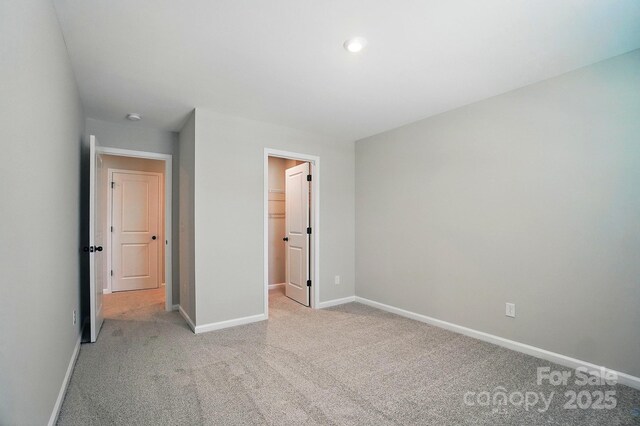 9843 Quercus Ln, Huntersville, NC 28078 - unfurnished bedroom with light colored carpet, baseboards, and a walk in closet