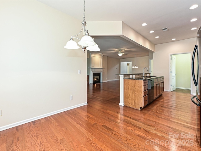 kitchen featuring dark wood-style floors, a ceiling fan, visible vents, black appliances, and open floor plan