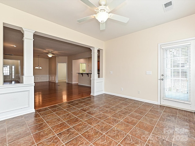 unfurnished room with visible vents, baseboards, ceiling fan, and ornate columns