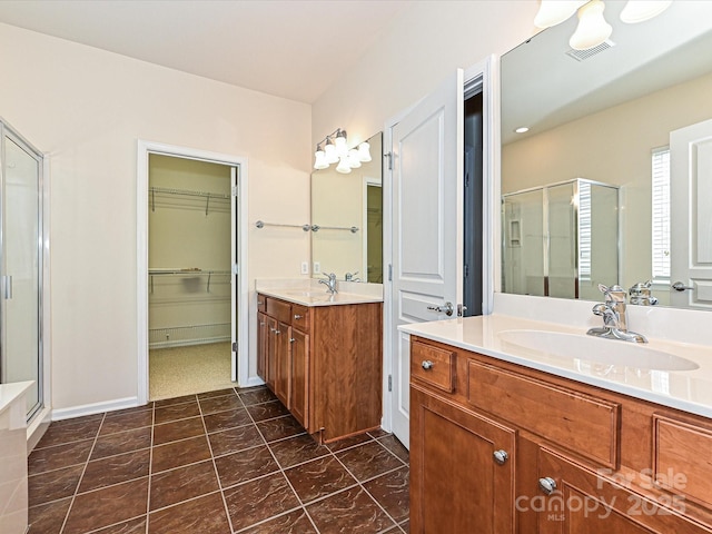 bathroom featuring visible vents, a stall shower, two vanities, and a sink