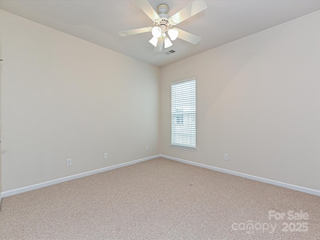 empty room with light carpet, visible vents, a ceiling fan, and baseboards