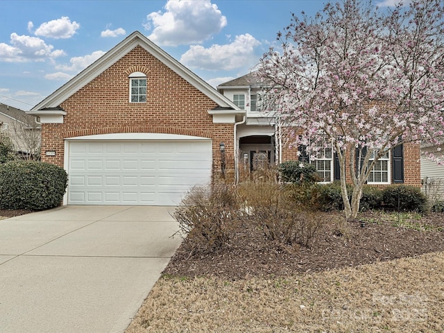 view of front facade with a garage, brick siding, and concrete driveway