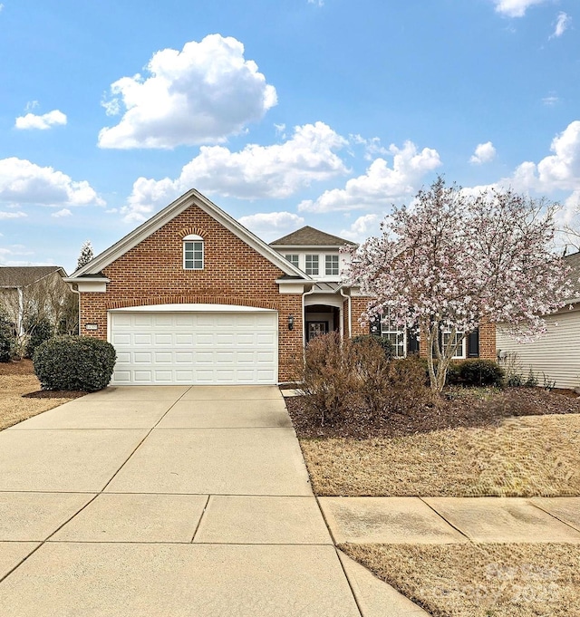 view of front of property with brick siding, driveway, and a garage