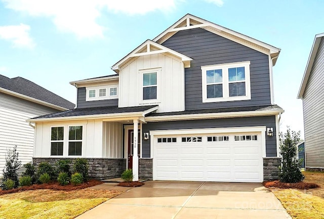 craftsman house featuring an attached garage, board and batten siding, stone siding, and concrete driveway