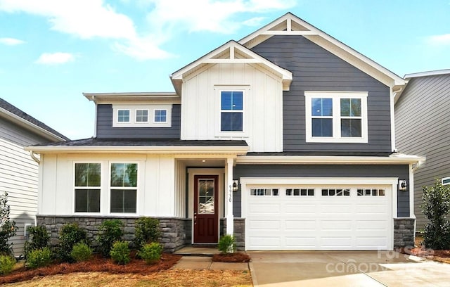 craftsman house featuring an attached garage, board and batten siding, driveway, and stone siding