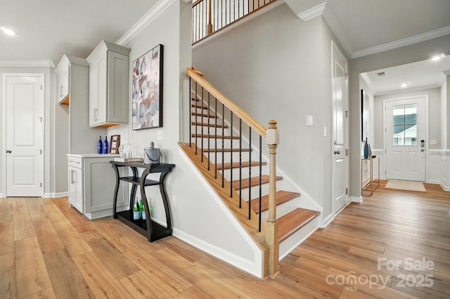 stairs featuring baseboards, ornamental molding, and hardwood / wood-style floors