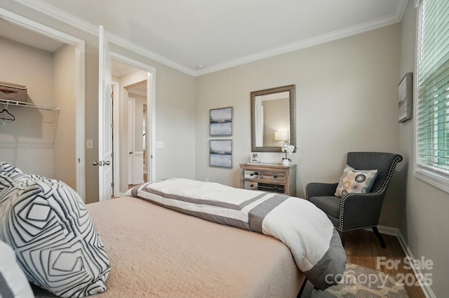 bedroom with baseboards, ornamental molding, and wood finished floors