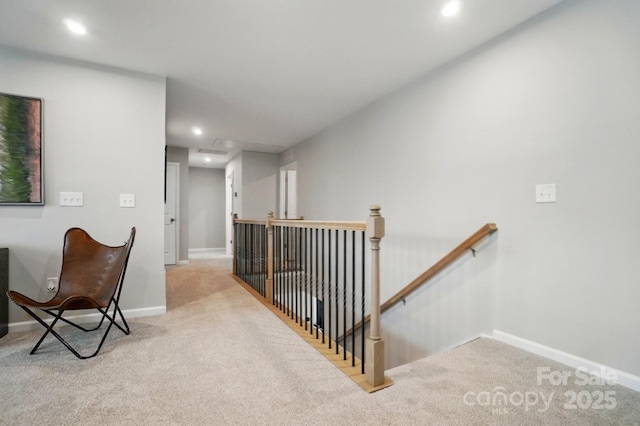 hall featuring carpet floors, baseboards, recessed lighting, and an upstairs landing