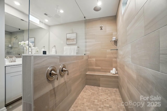 full bath featuring a walk in shower, vanity, recessed lighting, and visible vents