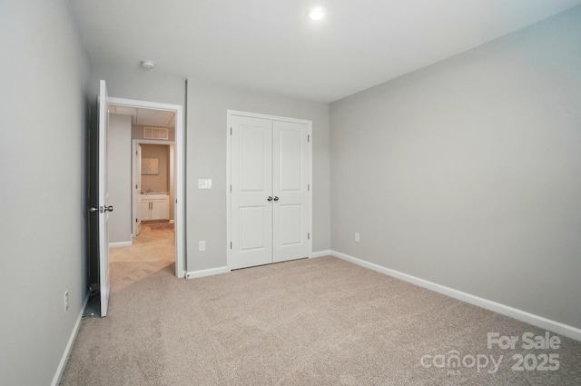 unfurnished bedroom featuring carpet flooring, baseboards, and a closet