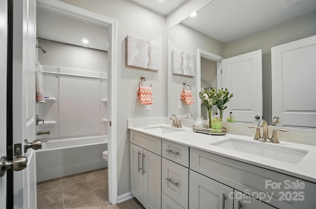 bathroom with a sink, tile patterned flooring, toilet, and double vanity
