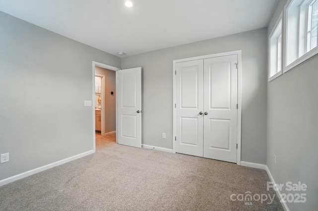 unfurnished bedroom featuring carpet flooring, baseboards, and a closet