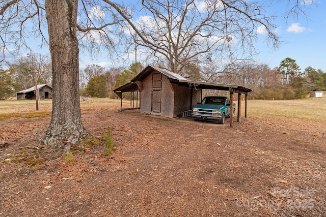 view of outdoor structure with a carport and driveway