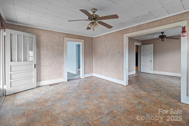 unfurnished room with visible vents, stone finish flooring, ceiling fan, baseboards, and ornamental molding