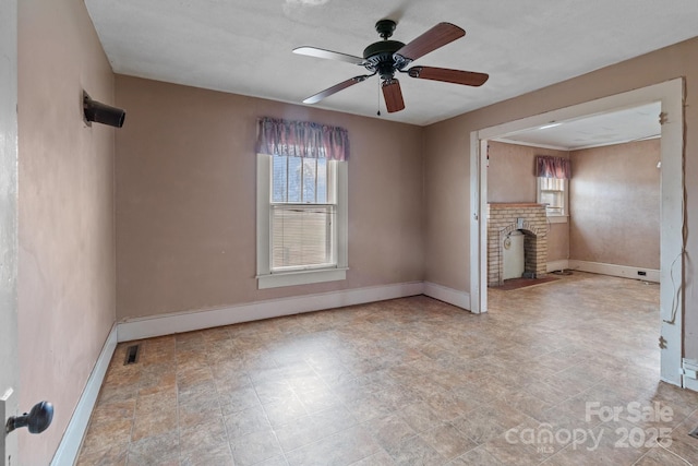 unfurnished living room with a ceiling fan, visible vents, a fireplace, and baseboards