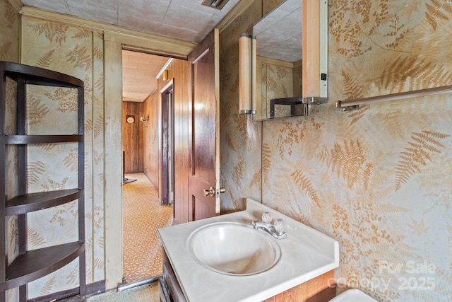 bathroom featuring wallpapered walls and vanity