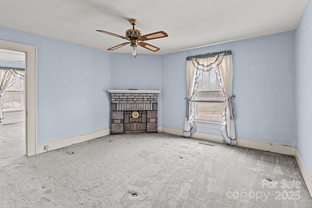 unfurnished room with a ceiling fan, visible vents, baseboards, a fireplace, and carpet flooring