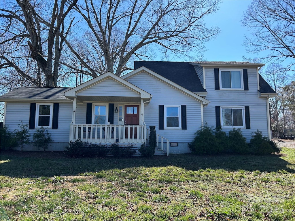 traditional-style home featuring crawl space, a porch, and a front lawn