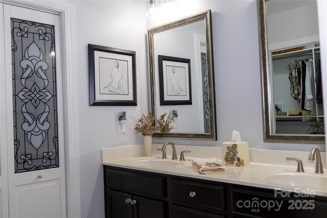 full bathroom with a sink and double vanity