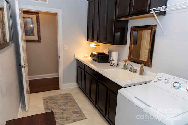 laundry area featuring cabinet space, baseboards, visible vents, washer / clothes dryer, and a sink