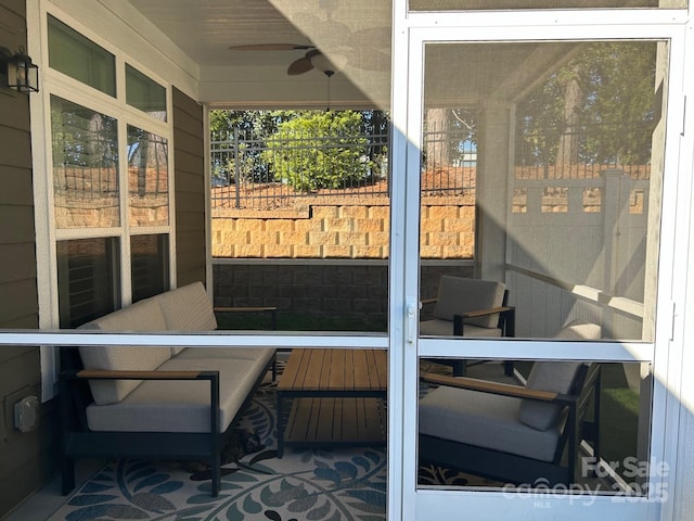 sunroom / solarium featuring ceiling fan