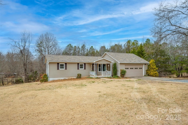 ranch-style home featuring a porch, a front yard, concrete driveway, and an attached garage