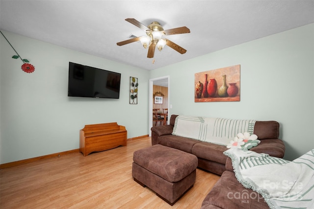 living room with light wood-type flooring, baseboards, and a ceiling fan