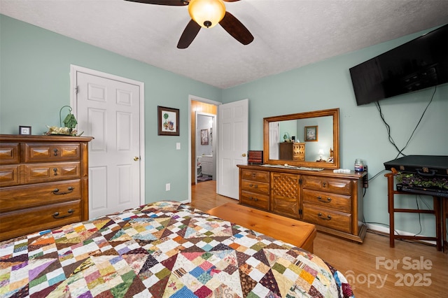 bedroom featuring a textured ceiling, ceiling fan, wood finished floors, and baseboards