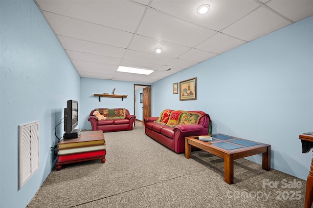 living room featuring carpet floors, a drop ceiling, and visible vents