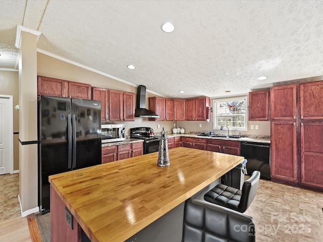 kitchen featuring reddish brown cabinets, black appliances, wall chimney range hood, and a sink