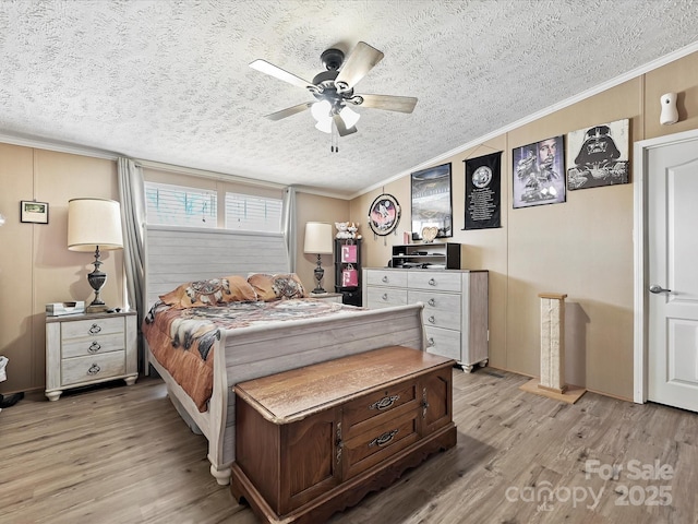 bedroom with light wood-style flooring, a textured ceiling, a ceiling fan, and crown molding