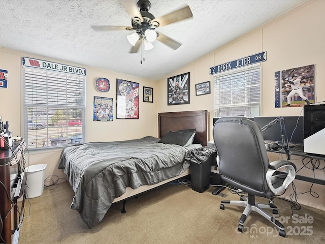 bedroom featuring carpet floors, lofted ceiling, a textured ceiling, and a ceiling fan