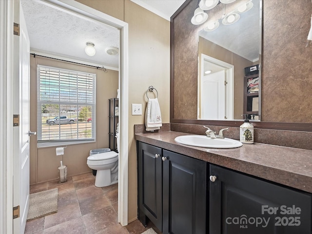 bathroom with vanity, toilet, and a textured ceiling