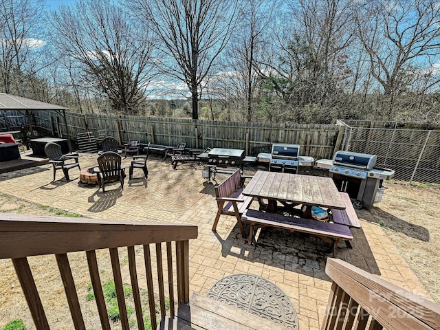 view of patio with a fire pit, outdoor dining area, area for grilling, and a fenced backyard