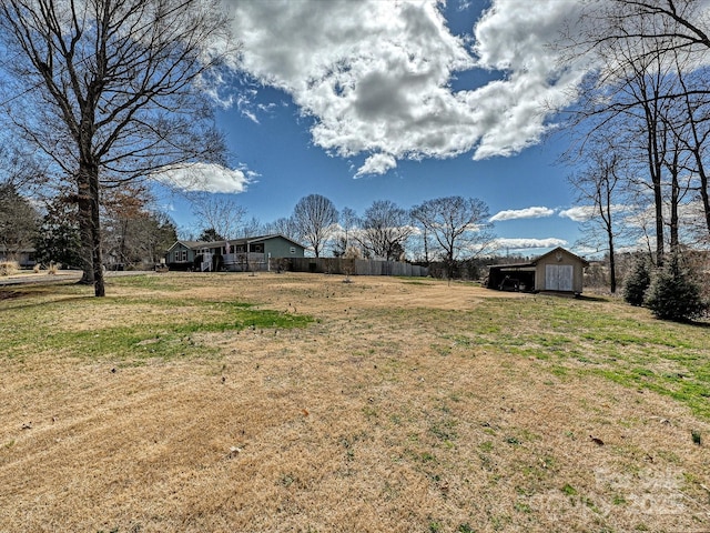 view of yard featuring an outdoor structure and fence