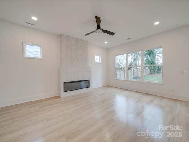 unfurnished living room featuring light wood-style flooring, a tile fireplace, visible vents, and recessed lighting