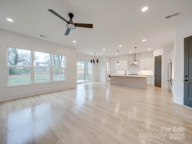 unfurnished living room with light wood-style flooring, visible vents, and recessed lighting