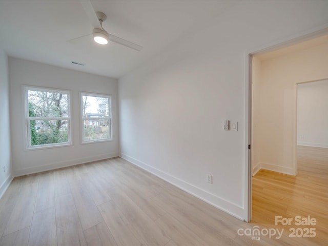 empty room featuring baseboards, ceiling fan, visible vents, and light wood finished floors