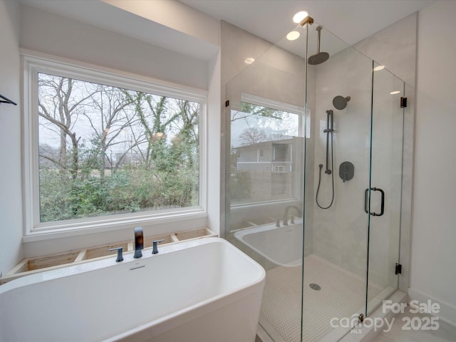 bathroom with a soaking tub and a shower stall