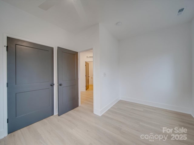 unfurnished bedroom with baseboards, visible vents, and light wood finished floors