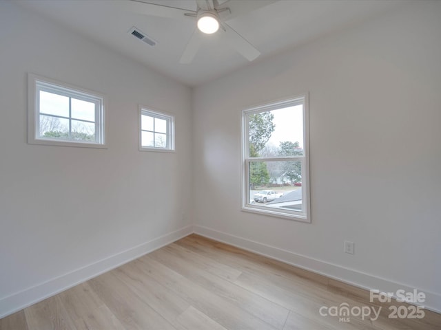 unfurnished room featuring light wood-style floors, baseboards, visible vents, and a ceiling fan