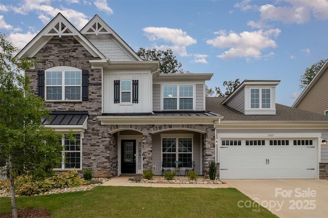 craftsman house with board and batten siding, a porch, concrete driveway, a front yard, and a standing seam roof