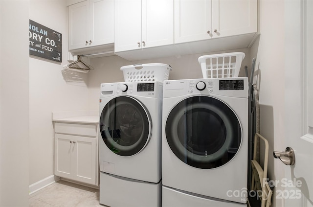 laundry room featuring separate washer and dryer, light tile patterned floors, and cabinet space