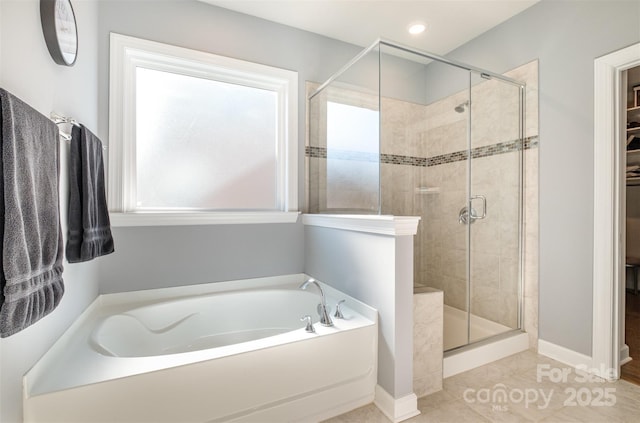 bathroom with baseboards, a garden tub, a stall shower, and tile patterned flooring