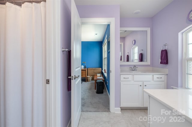 full bath featuring baseboards and vanity