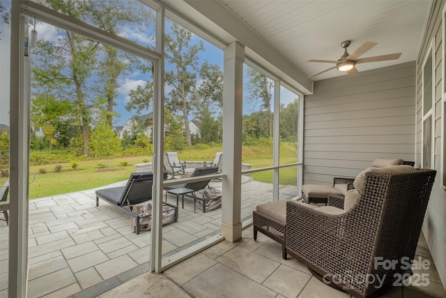 sunroom / solarium featuring a ceiling fan