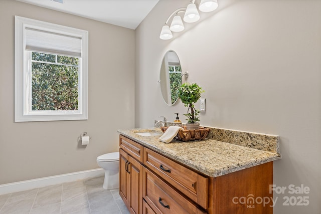 bathroom with tile patterned floors, toilet, vanity, and baseboards