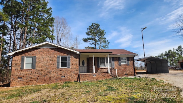 ranch-style home featuring driveway, a carport, covered porch, crawl space, and brick siding