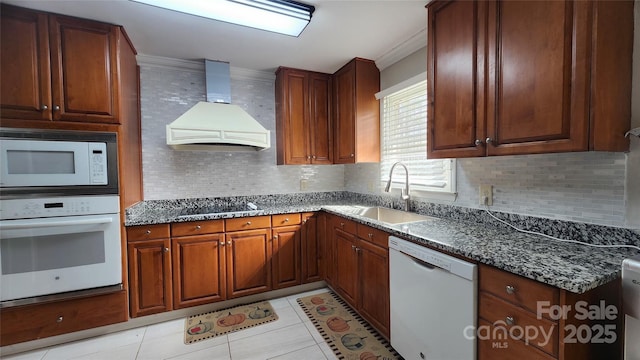 kitchen featuring a sink, tasteful backsplash, white appliances, light tile patterned floors, and custom exhaust hood